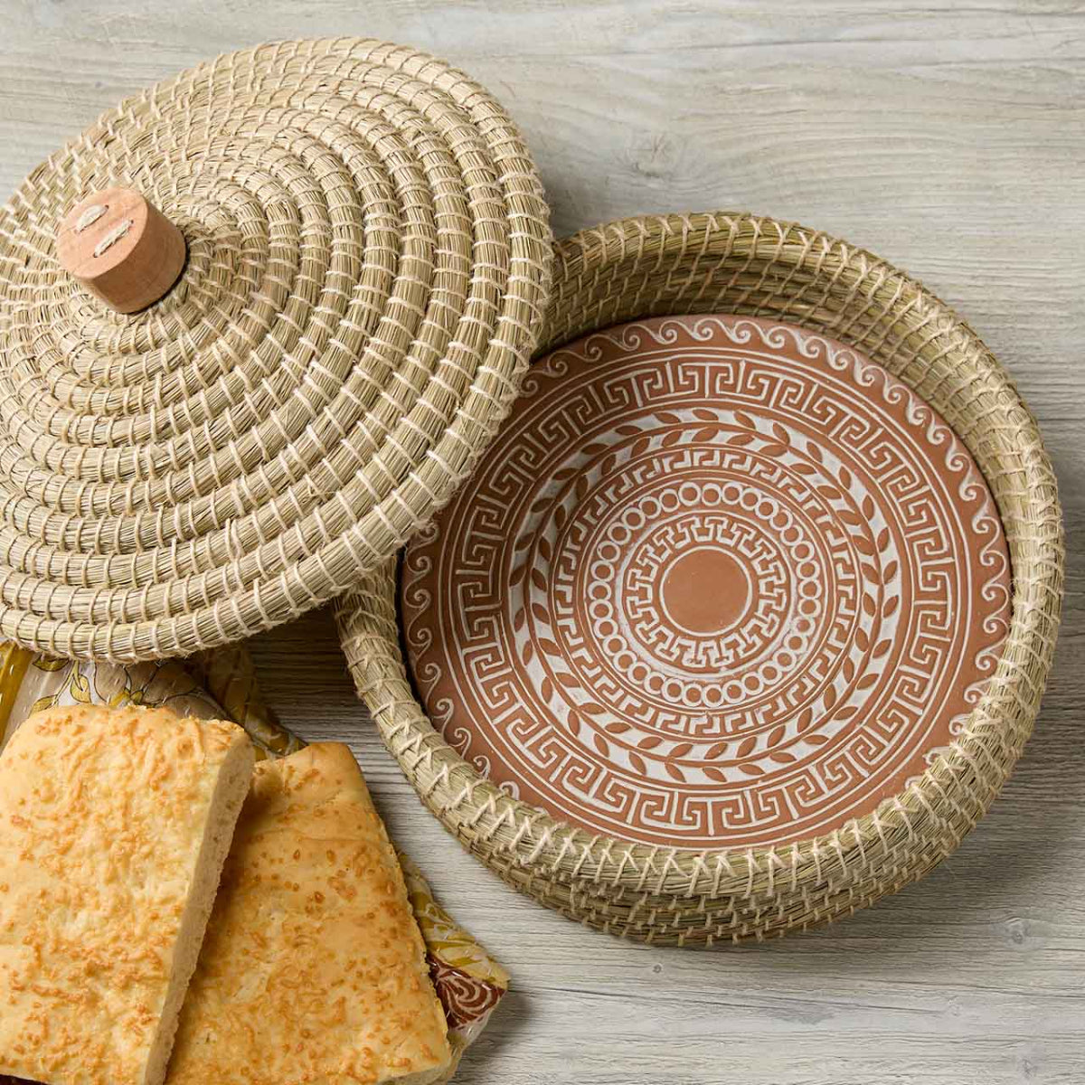 Woven basket with lid and patterned interior on a wooden surface
