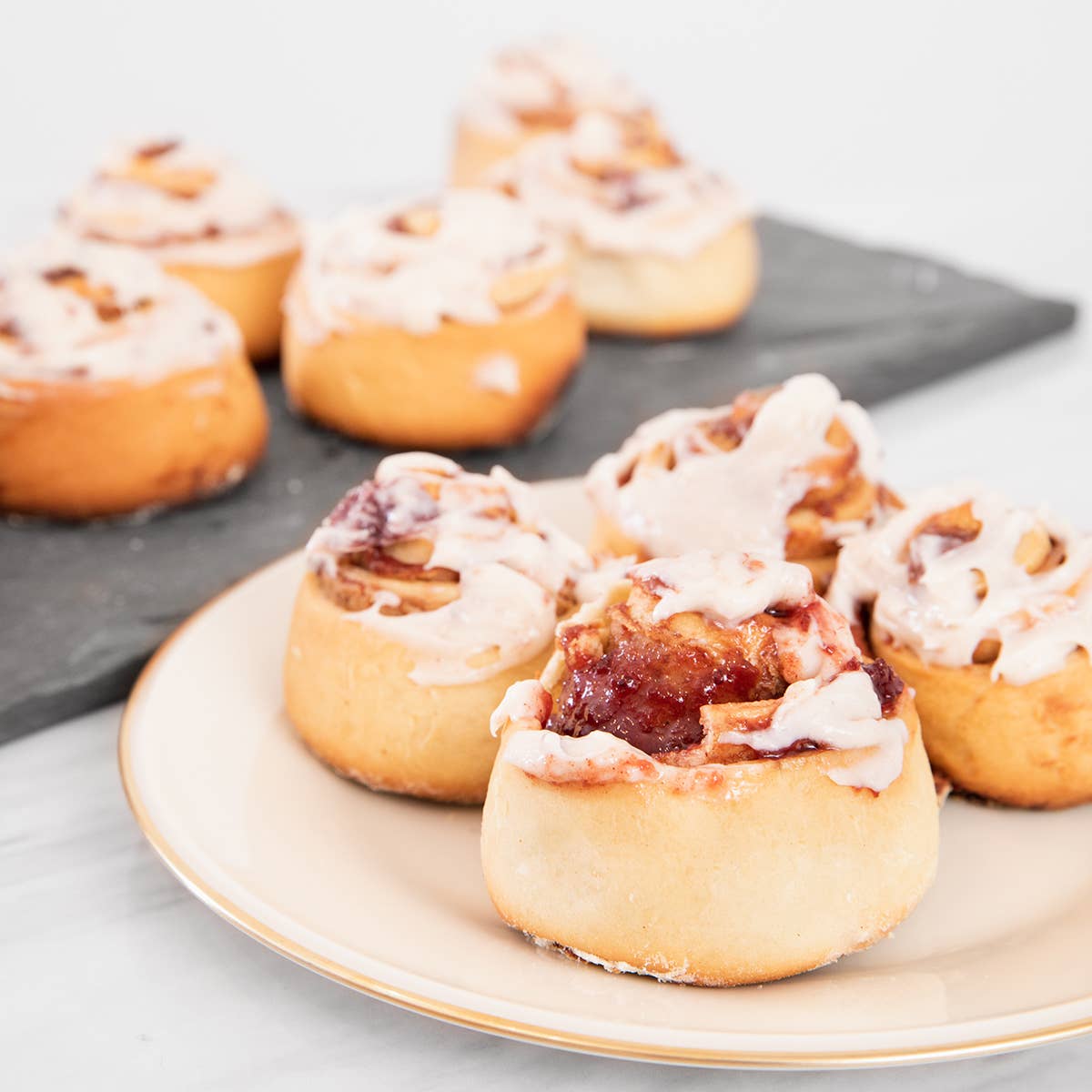 Cinnamon rolls with icing on a plate and tray