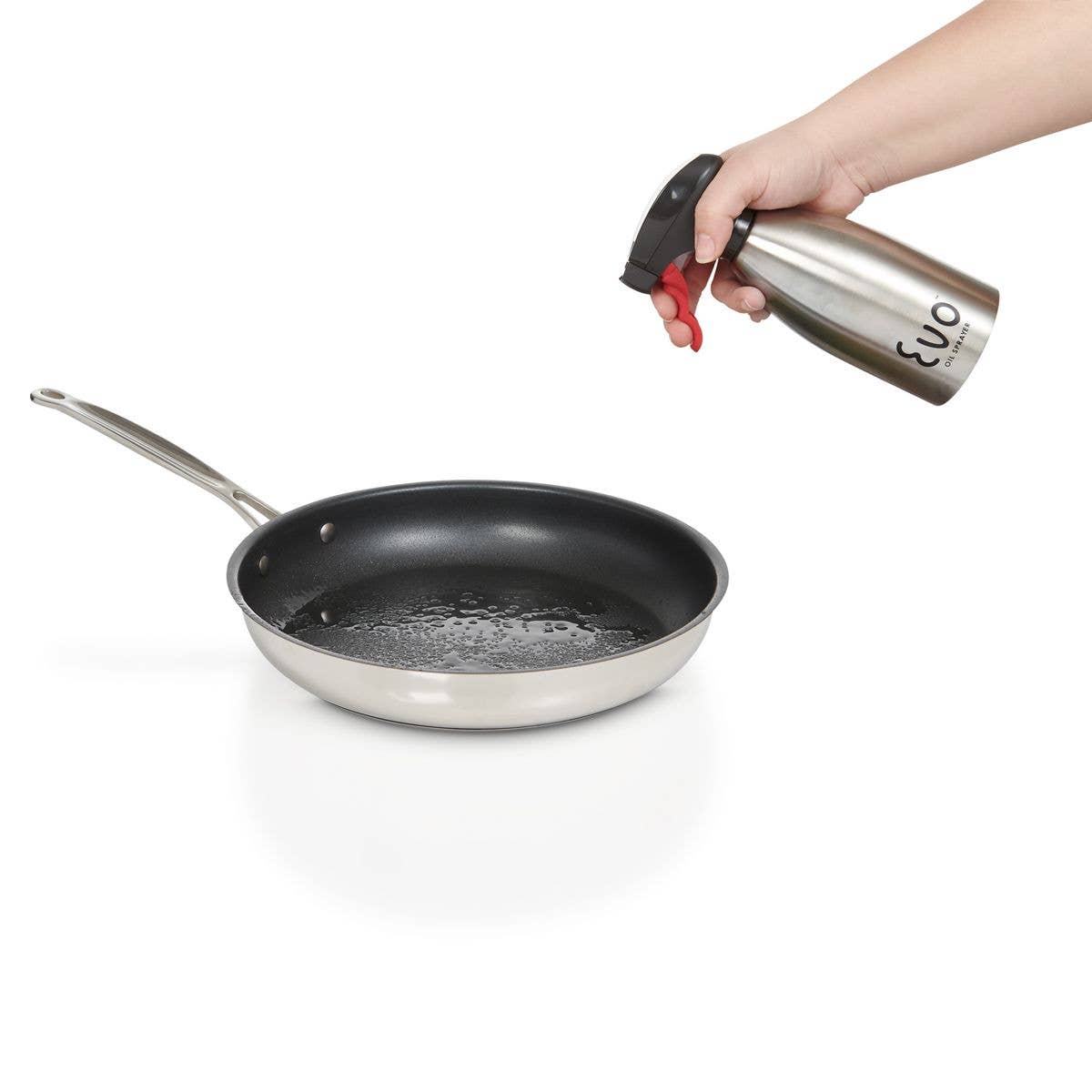 Person using a spray bottle labeled 'Evo' on a frying pan with oil.