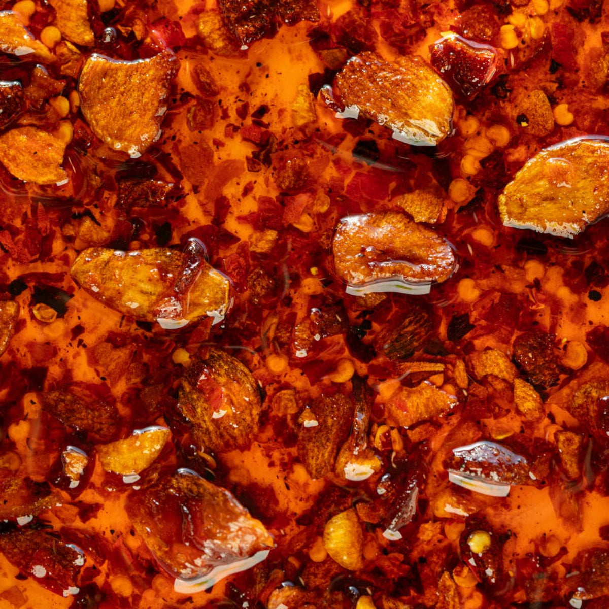 Close-up of a spicy dish with red chili oil and peanuts