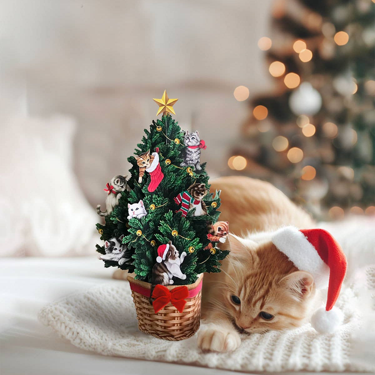 Cat wearing a Santa hat next to a small Christmas tree with decorative figures on a soft surface.