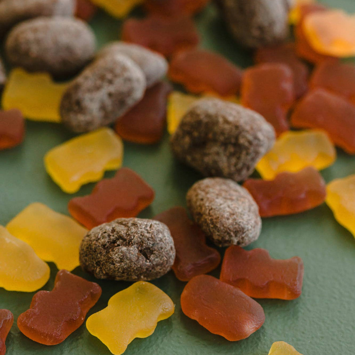 Assorted gummy bears on a green surface