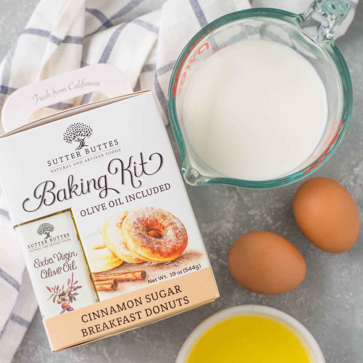 Baking kit with ingredients for cinnamon sugar breakfast donuts on a gray surface.
