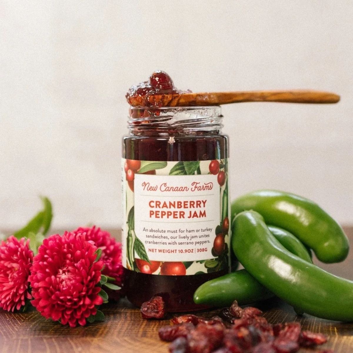 an open jar of cranberry pepper jam with fruit and peppers