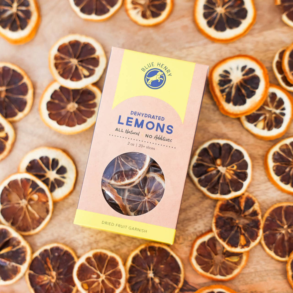 Dried lemons scattered on a wooden surface with a package labeled 'Perfumed Lemons' in the center.