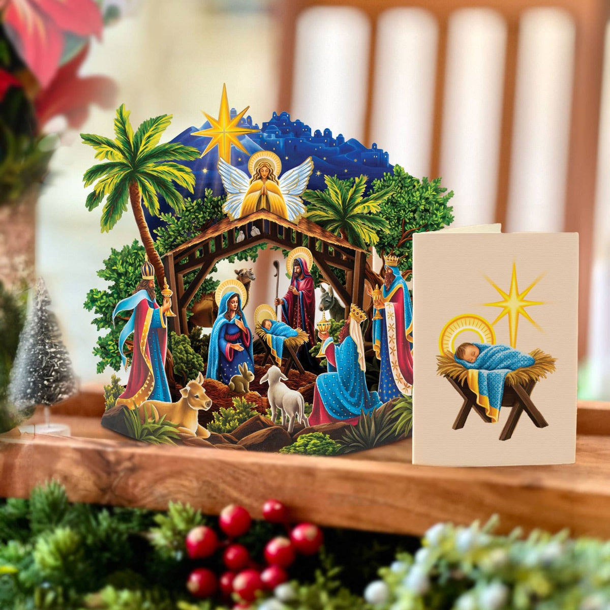 Christmas nativity scene with a card on a wooden surface.