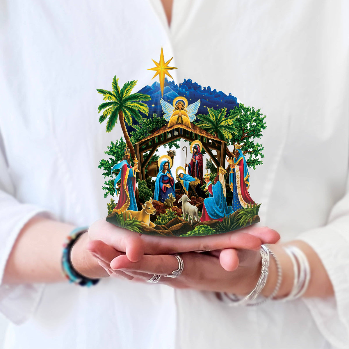 Nativity scene held in hands against a white shirt background