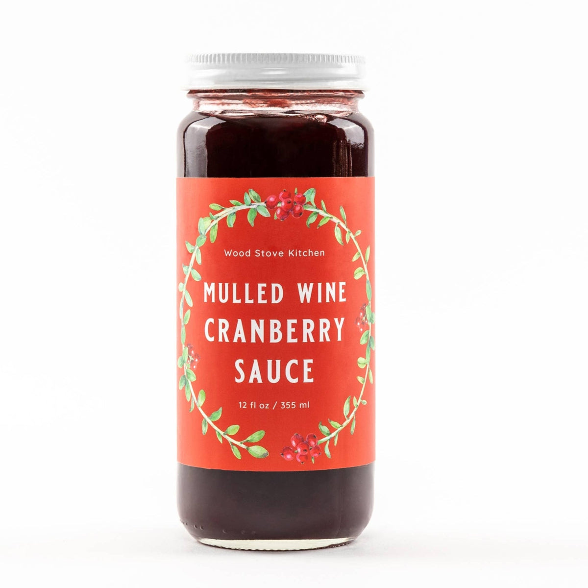 Jar of mulled wine cranberry sauce with a decorative label on a white background