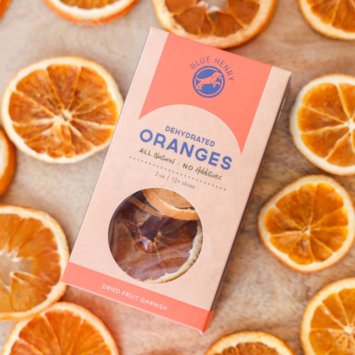 Dried oranges with a package labeled 'Dehydrated Oranges' on a wooden surface.