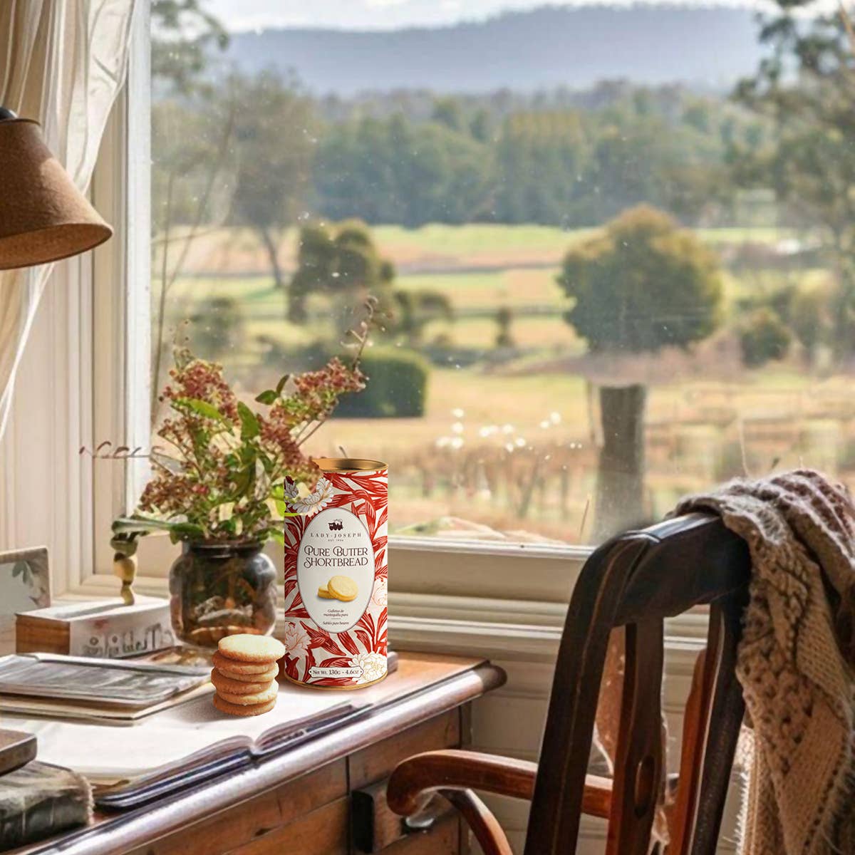 Desk with a jar of cookies and a view of a scenic landscape through a window.