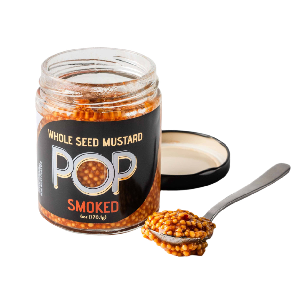 Jar of whole seed mustard with a spoonful on a light background