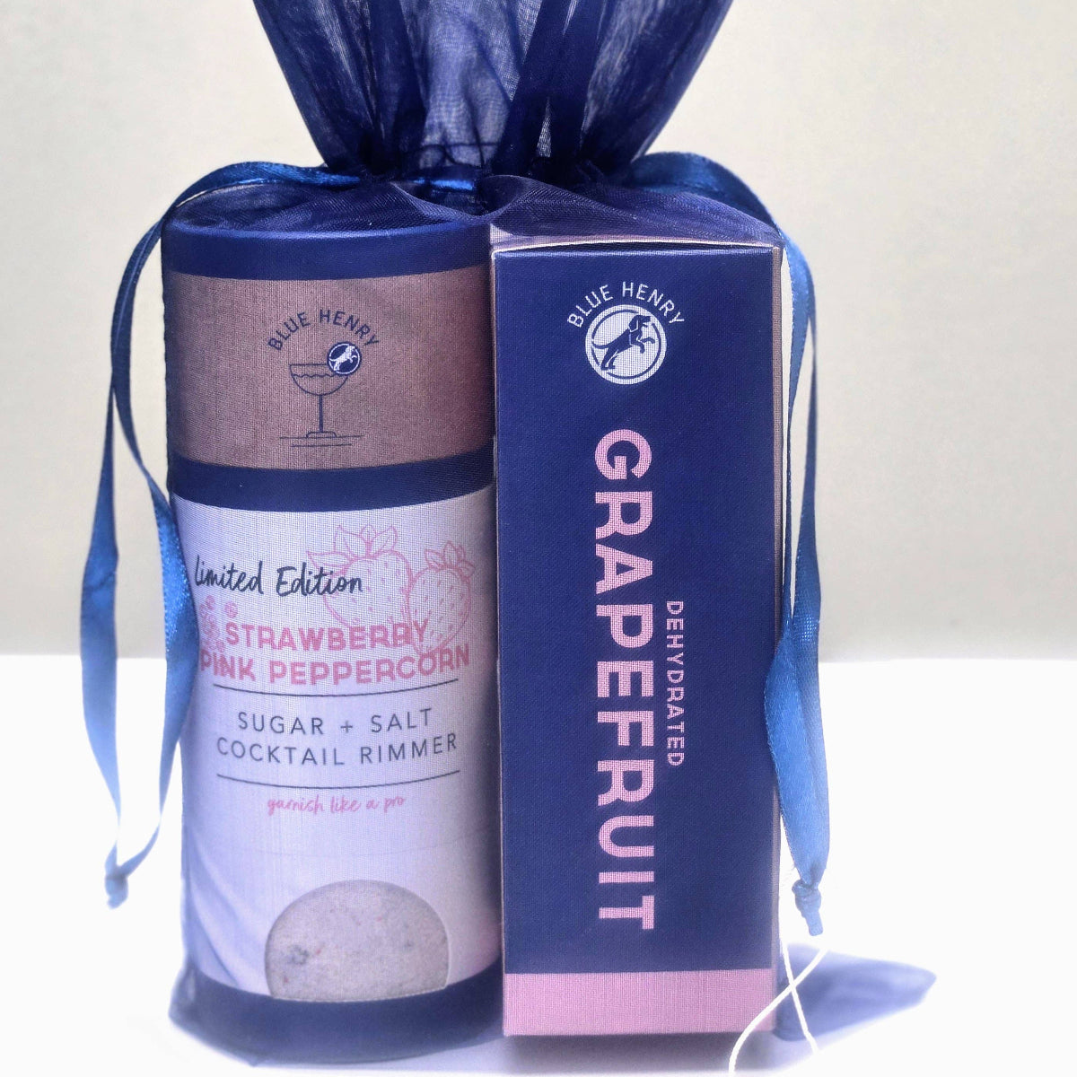 Two Blue Heron products, a canister and a box, with blue ribbons on a white background.