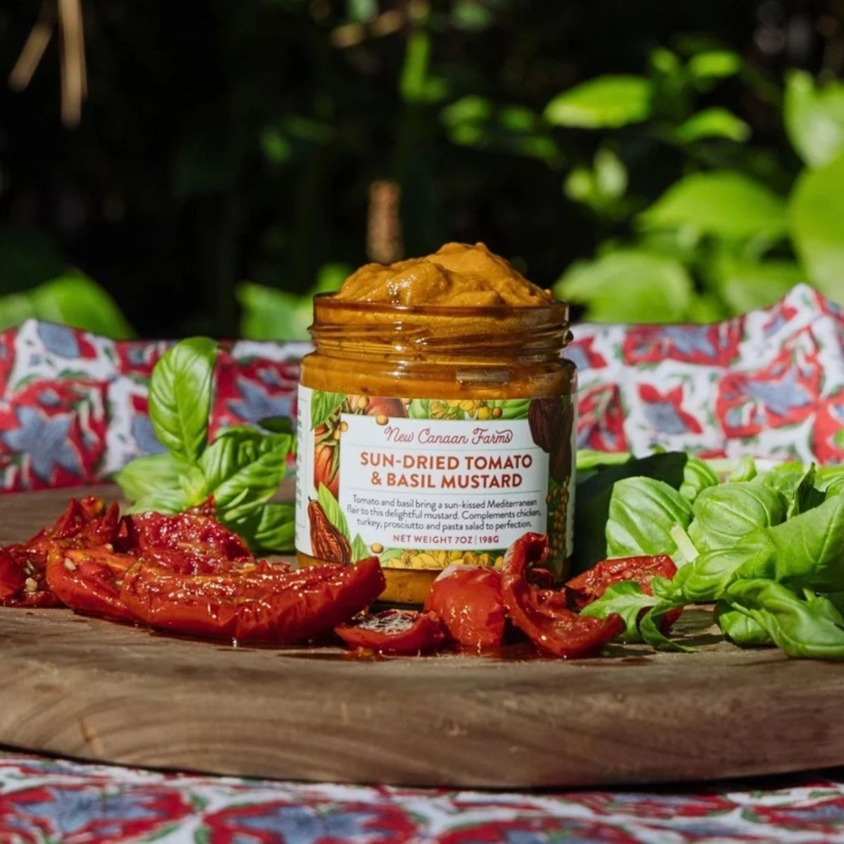 jar of mustard with basil and tomatoes surrounding it