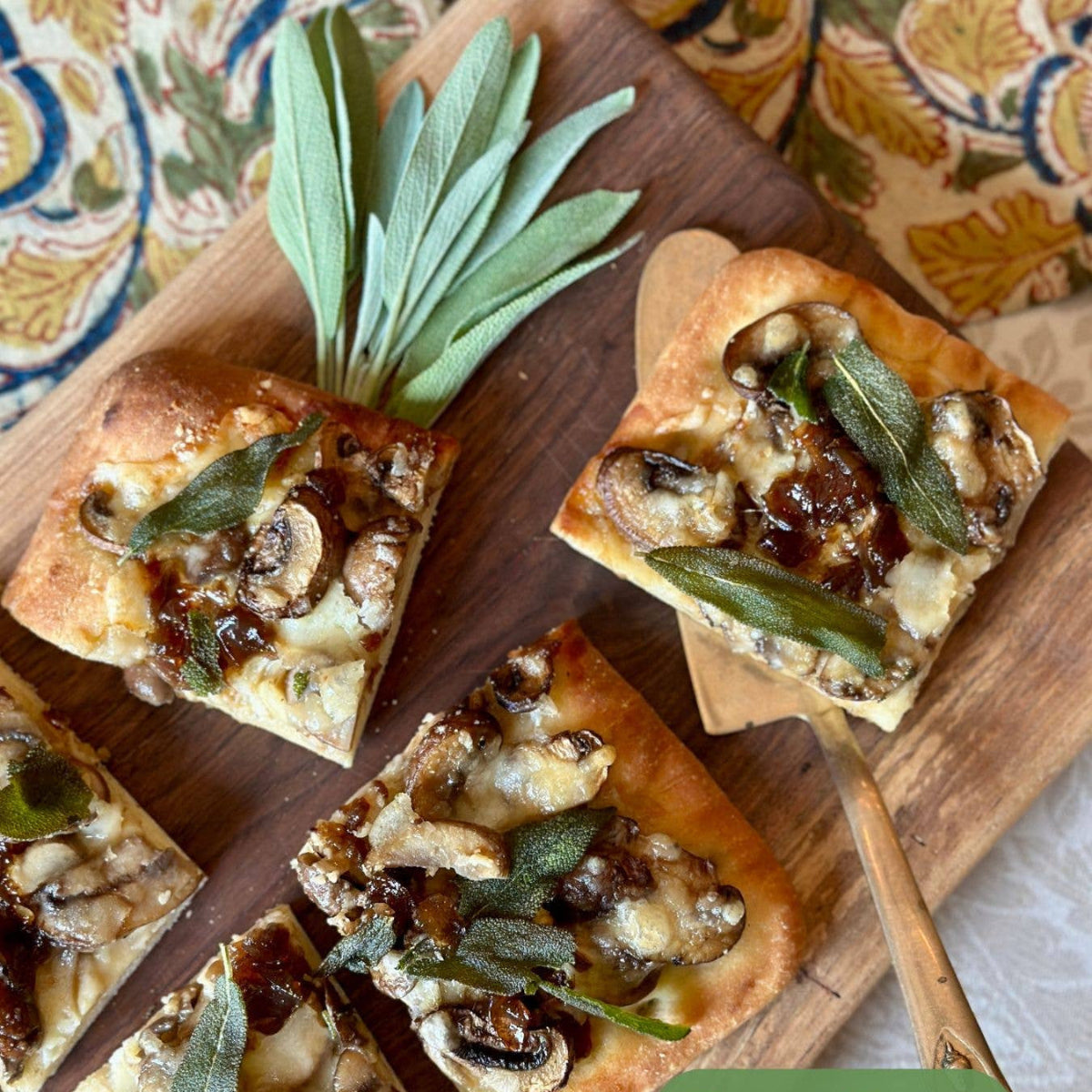 Mushroom and Fontina squares on a wooden board with sage leaves, branded 'Tait Farm'.