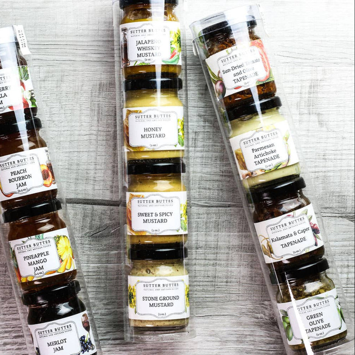 Set of miniature jam jars with labels on a wooden surface