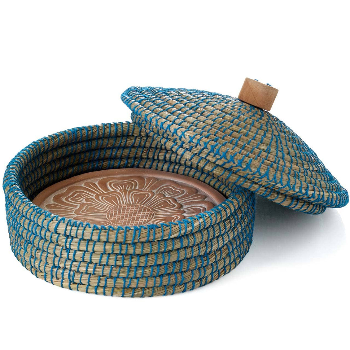 terra cotta dish with woven blue and beige lid on a white background