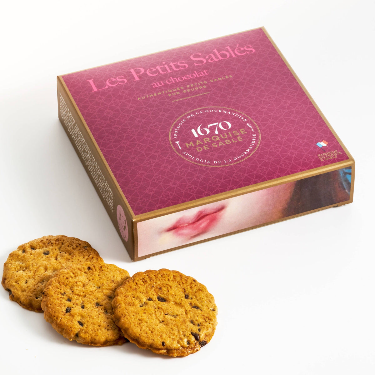 Box of Les Petits Sablés cookies with three cookies in front on a white background