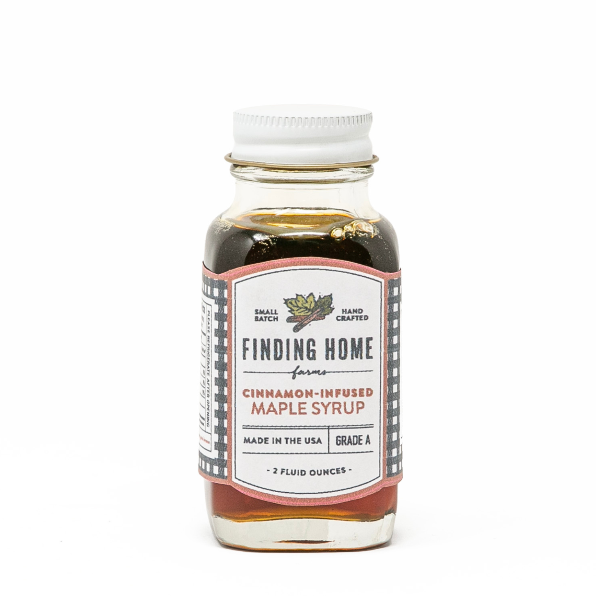 Bottle of Finding Home cinnamon-infused maple syrup on a white background