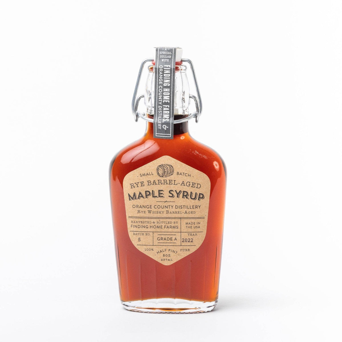 Bottle of rye barrel-aged maple syrup on a white background